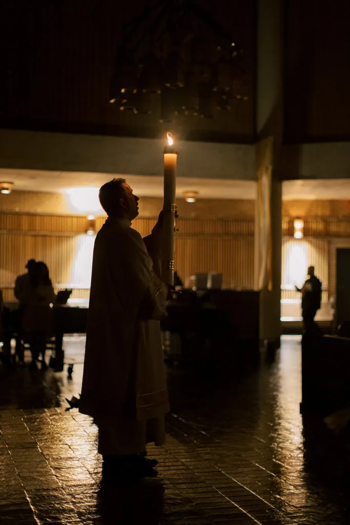 Deacon Ryan Sales holding the Paschal candle at the Easter Vigil